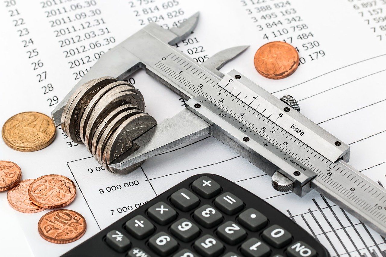 Taschenrechner, Münzen und Kalkulation: Einsparungen, um Schulden loszuwerden