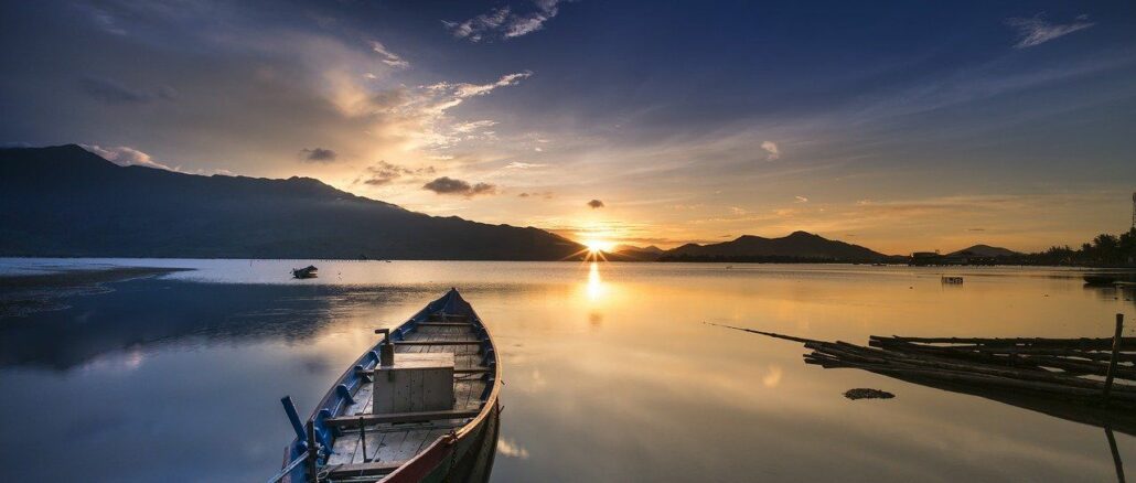 Askese und Seelenruhe Ein Boot in einem See plus Sonnenuntergang: Seelenruhe ist dank Verzicht und Askese möglich!