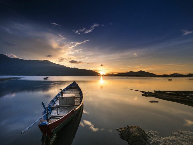 Ein Boot in einem See plus Sonnenuntergang: Seelenruhe ist dank Verzicht und Askese möglich!