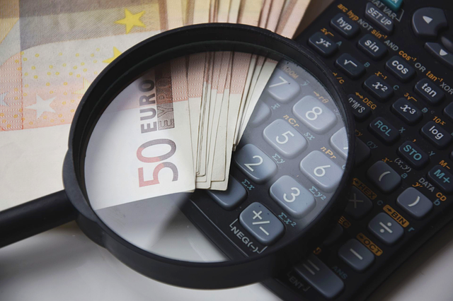 Taschenrechner, Lupe und einige 50-Euro-Banknoten: Man kann die komplizierte Kreditberechnung mit dem eigenen Taschenrechner durchführen. Oder man nutzt einfach den Kreditrechner von Kredit-Markt.eu