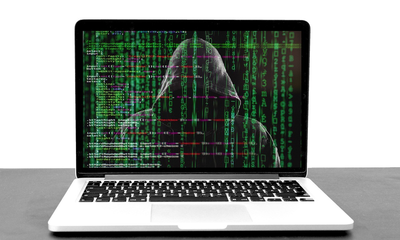 Laptop mit einem Hacker und Codes auf dem Bildschirm: Sparkasse Phishing Mails haben Konjunktur!
