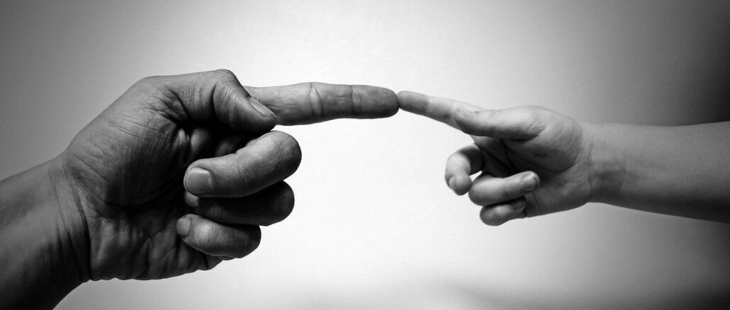 Finger eines Erwachsenen und Finger eines Kindes, die sich berühren: Sparen für den Nachwuchs kann sehr sinnvoll für Ihr Kind / Ihre Kinder sein!